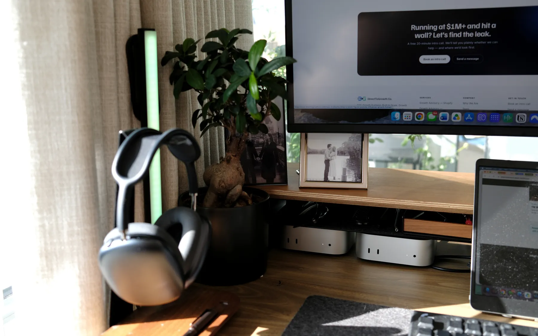 AirPods Max on a stand beside the bonsai, two Mac minis under the shelf